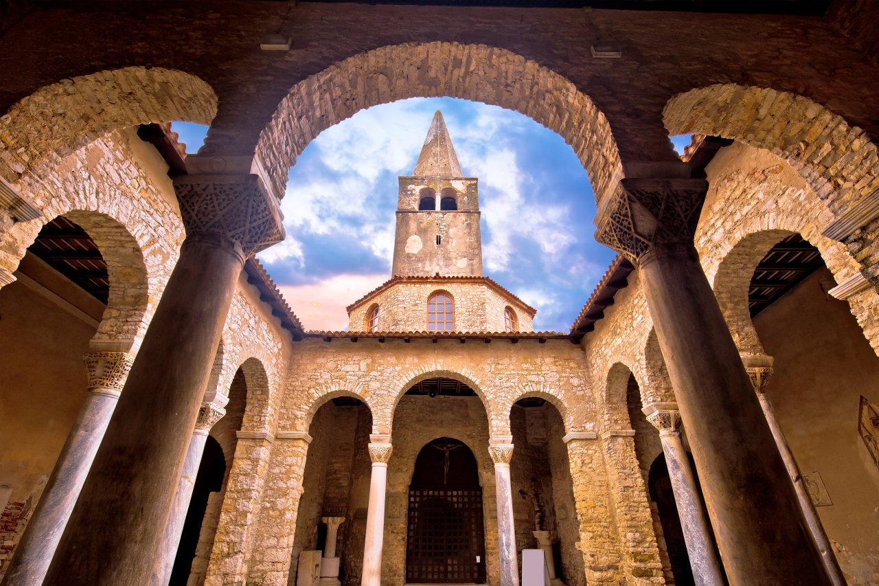 Euphrasian Basilica in Poreč with arches, columns, and a bell tower
