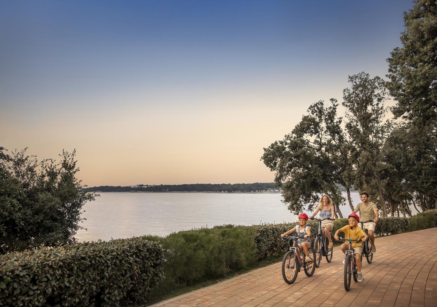 Obitelj uživa u vožnji bicikla uz more u Valamar Camping Istra