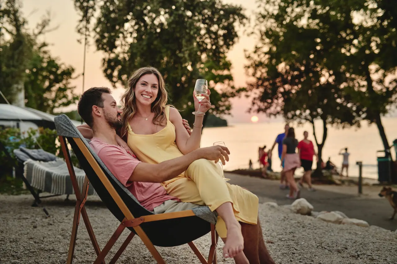 Pärchen genießt ein Glas Wein auf einem Campingplatz in Kroatien