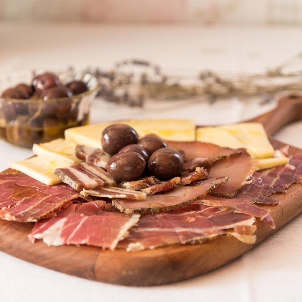  A plate of prosciutto, cheese and olives