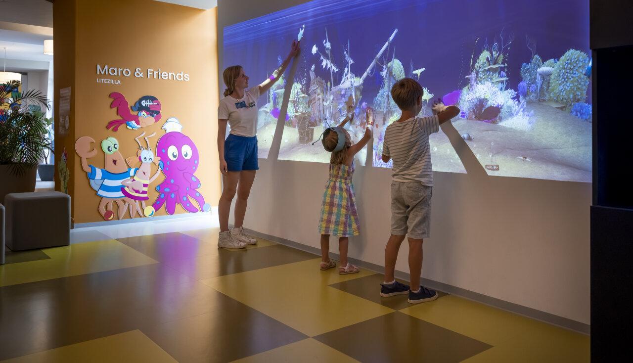 Kinder spielen mit einer Betreuerin im Maro Spielzimmer