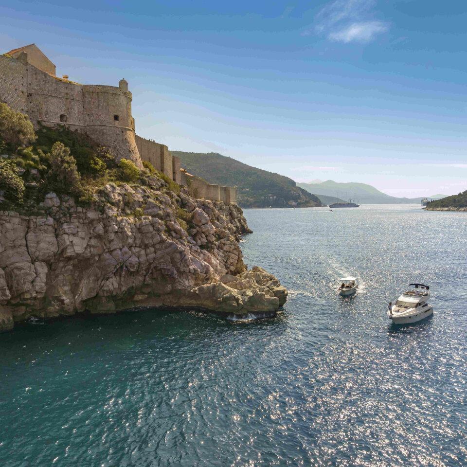 A boat in the Adriatic Sea near the historic Old Town of Dubrovnik, showcasing the city's stunning coastal location
