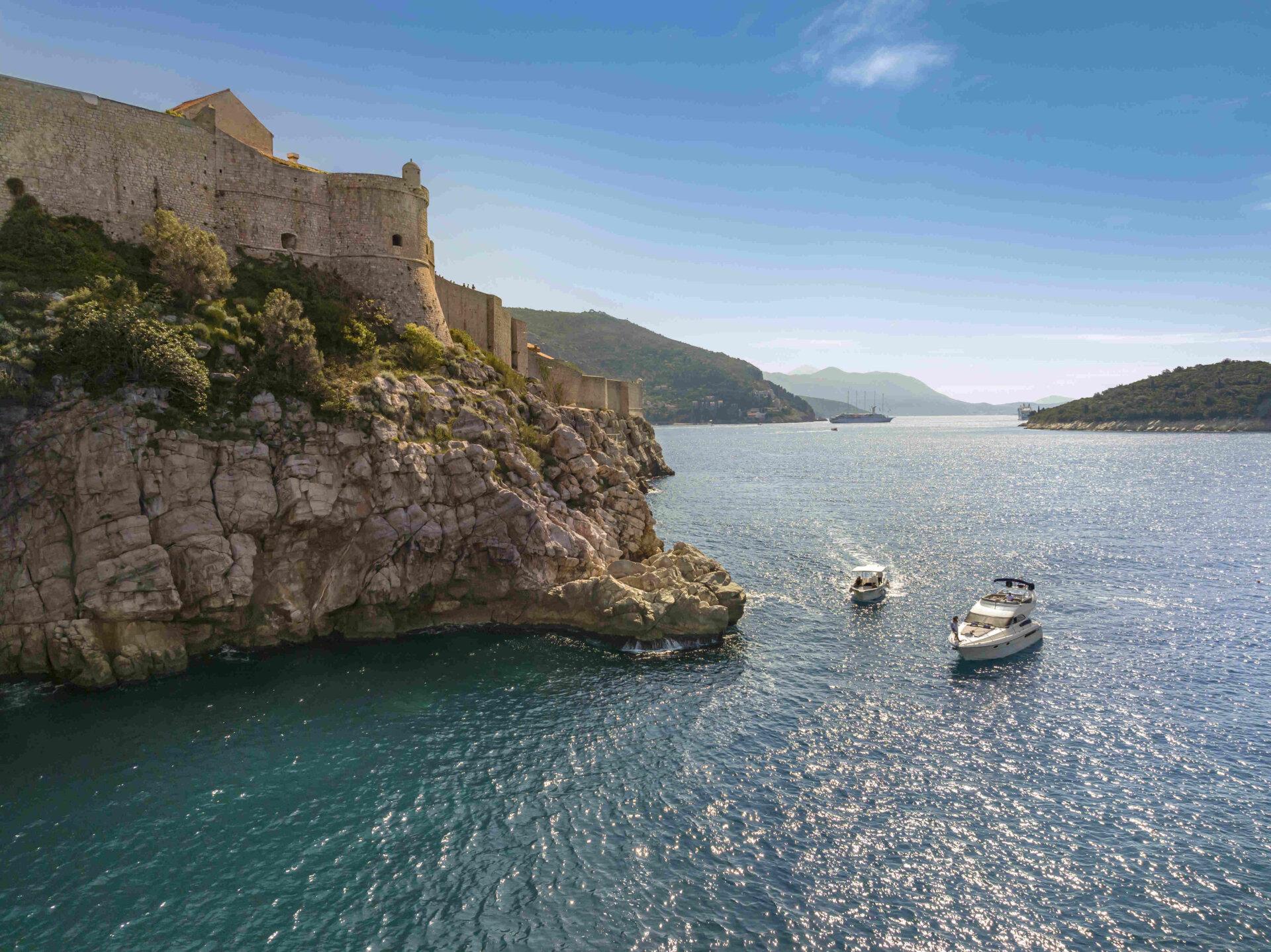 A boat in the Adriatic Sea near the historic Old Town of Dubrovnik, showcasing the city's stunning coastal location
