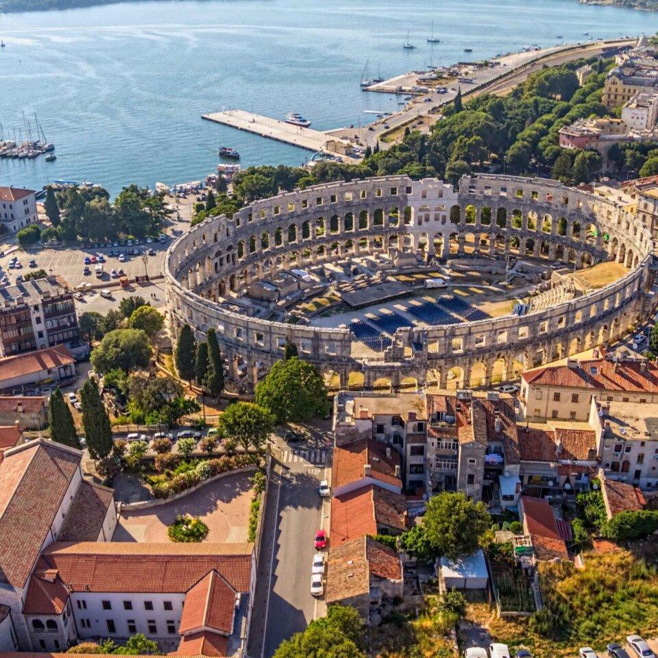 Aerial view of the Pula Arena with a sea.
