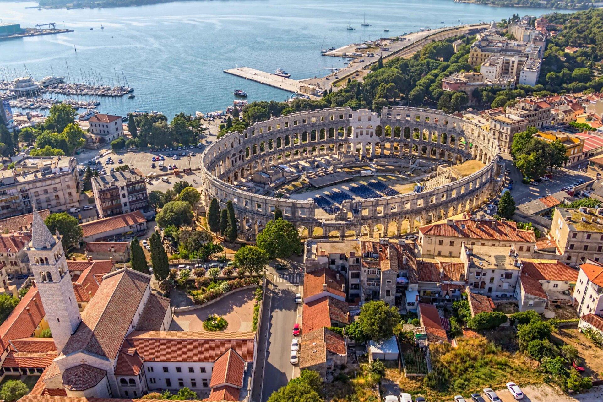 Aerial view of the Pula Arena with a sea.