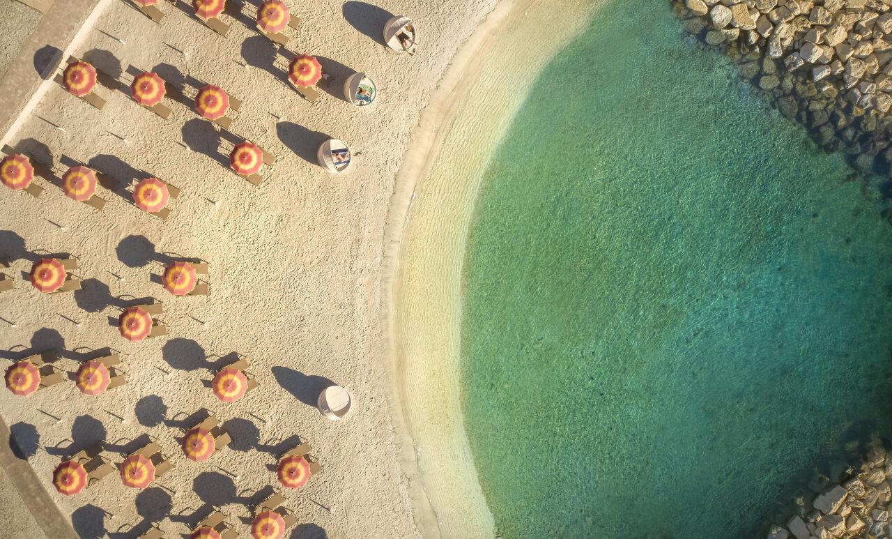 Pje&scaron;čana obiteljska plaža sa &scaron;arenim suncobranima u Isabella Island Resortu u Poreču