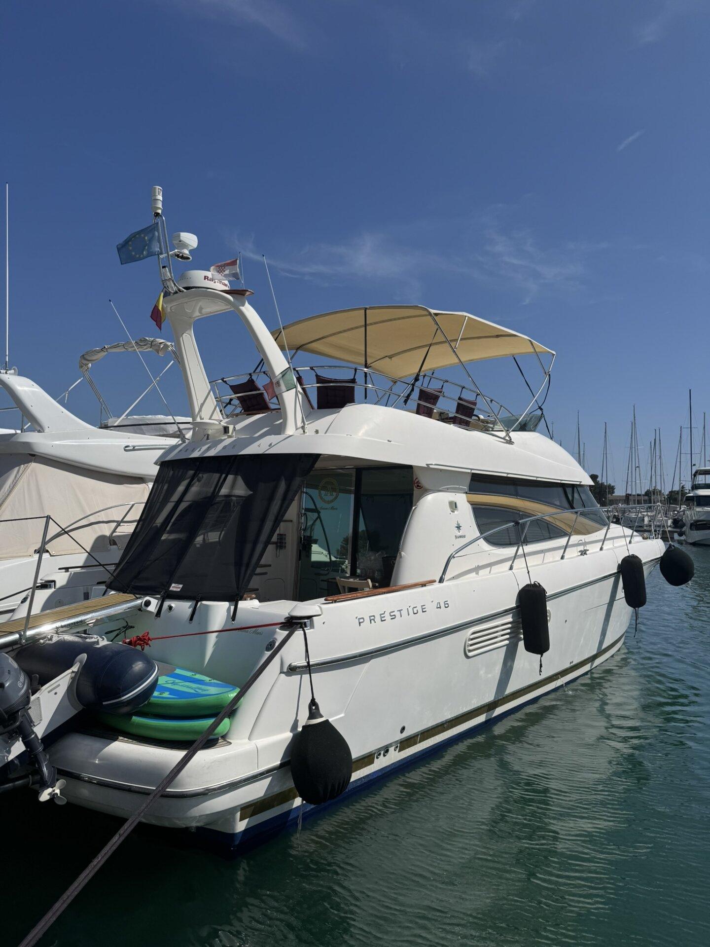 Motorna jahta Prestige 46 usidrena u marini pod vedrim plavim nebom.