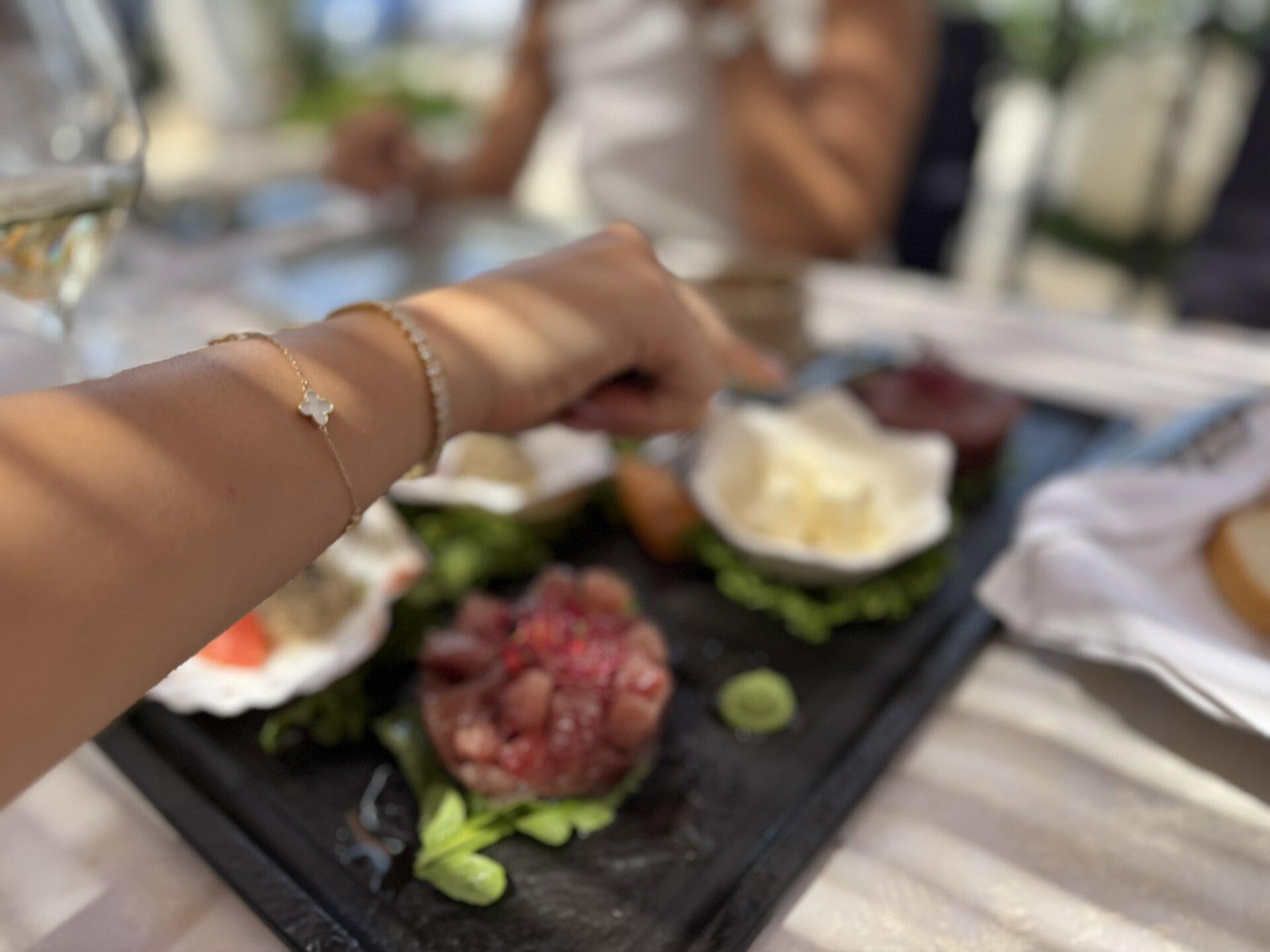 Eine Person streckt ihren Arm zu einem Gourmet-Teller mit Meeresfrüchten aus