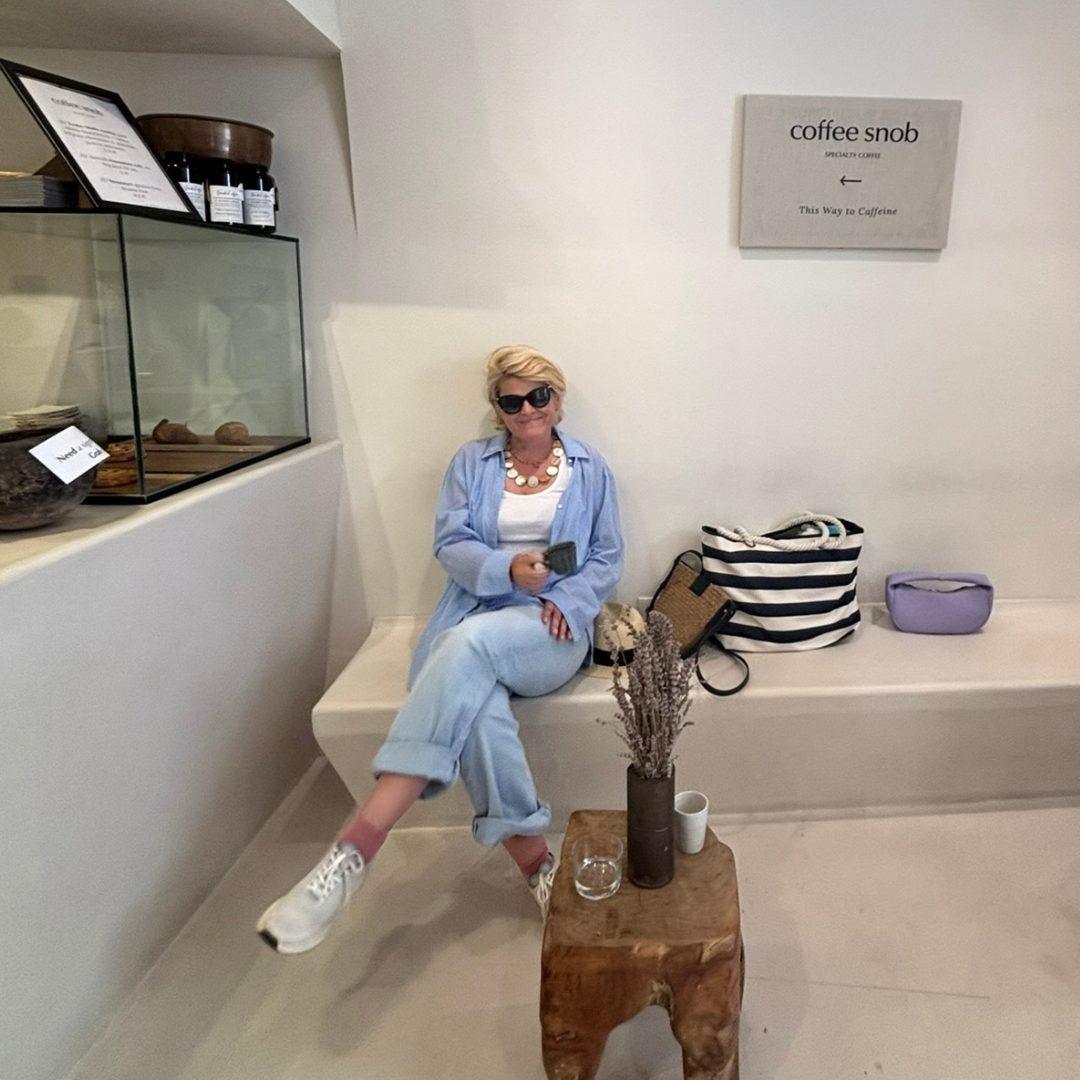 Woman relaxing with a coffee inside Coffee Snob in Hvar, a minimalist speciality café.