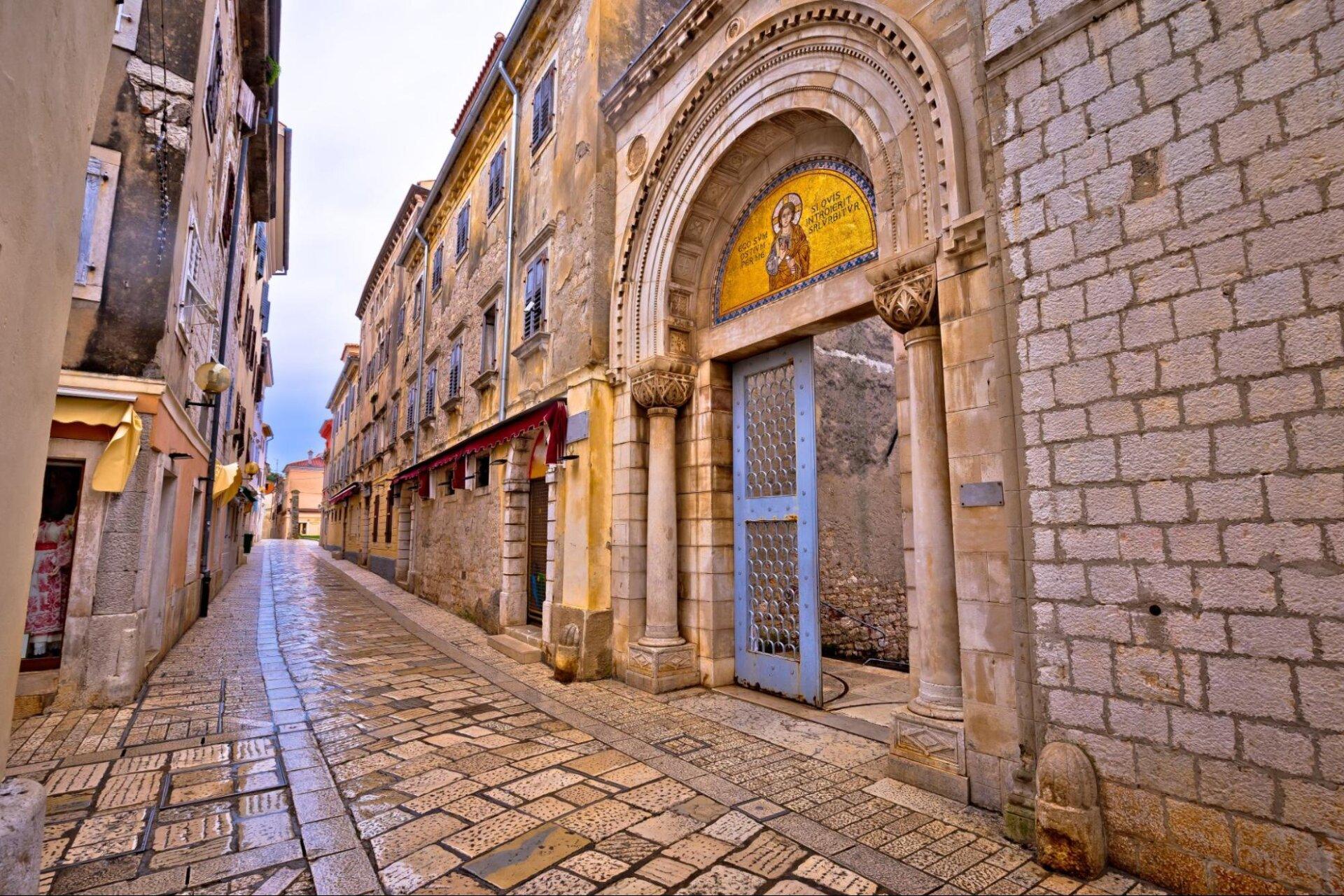 Eingang in eine alte Kirche mit Mosaiken und Steingasen in der Altstadt von Poreč