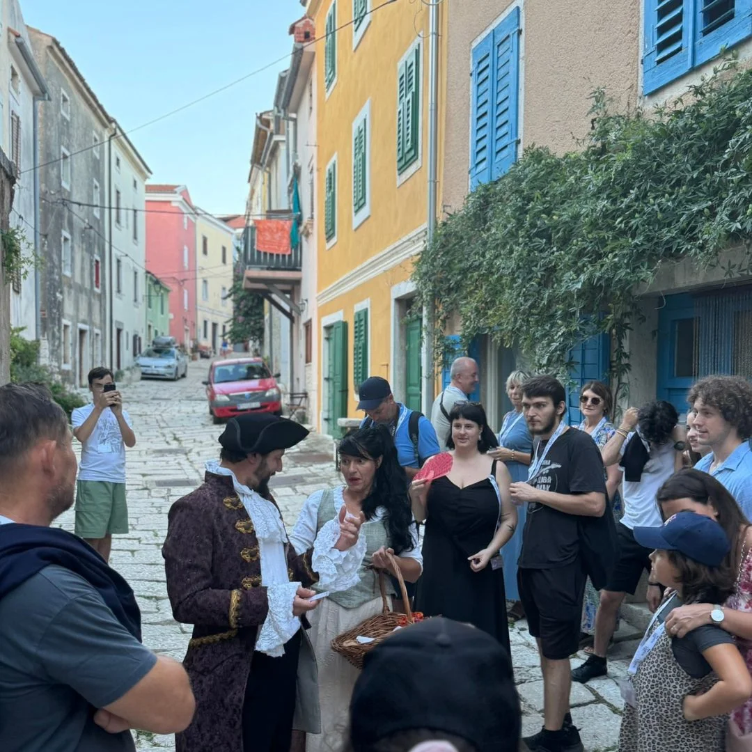 Eine Interaktion zwischen den Darstellern und dem Publikum w&auml;hrend der Casanova-Tour auf einer bunten Kopfsteinpflasterstra&szlig;e in Vrsar. 