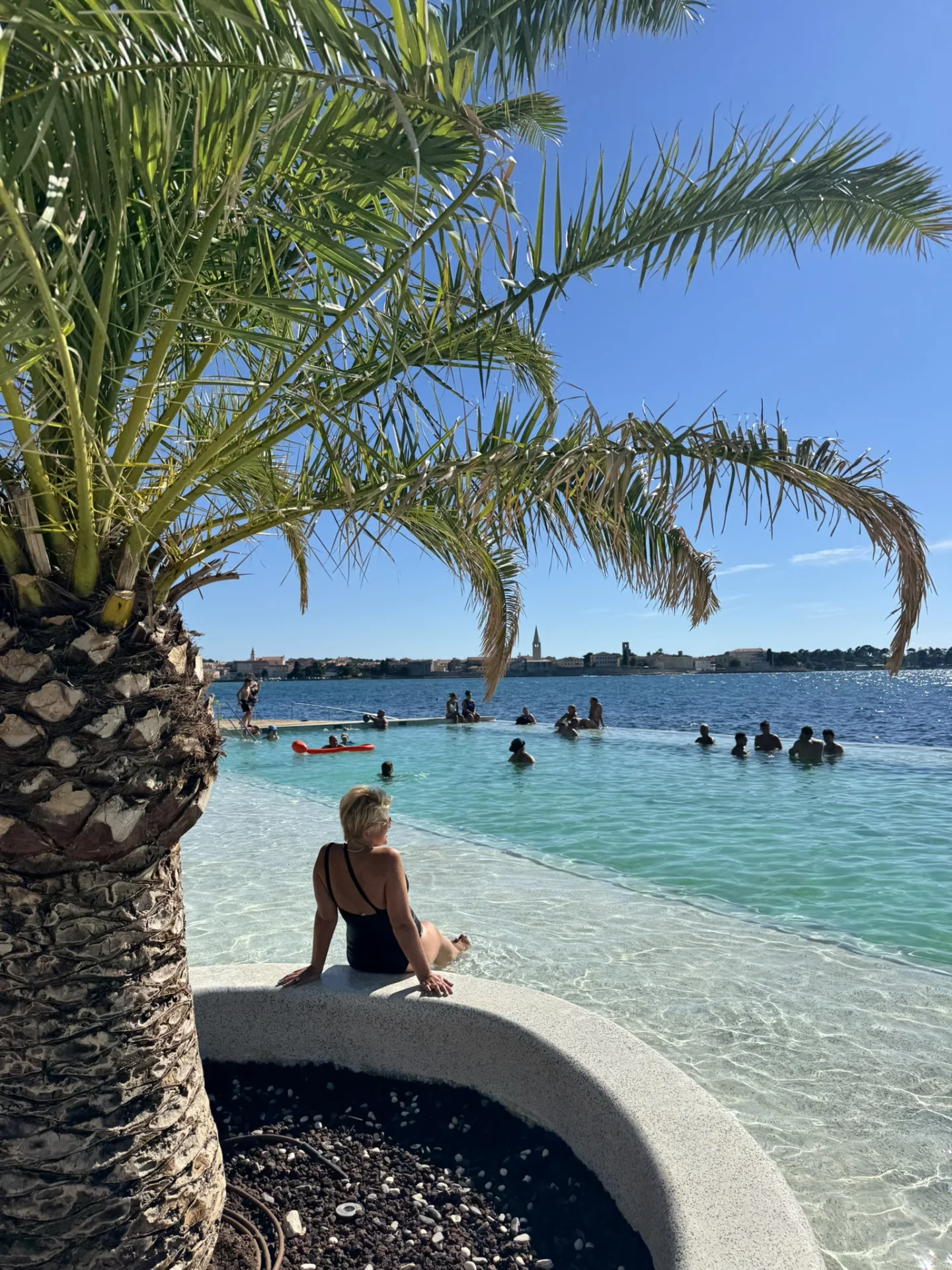 Žena se opušta u infinity bazenu s pogledom na more i Poreč.