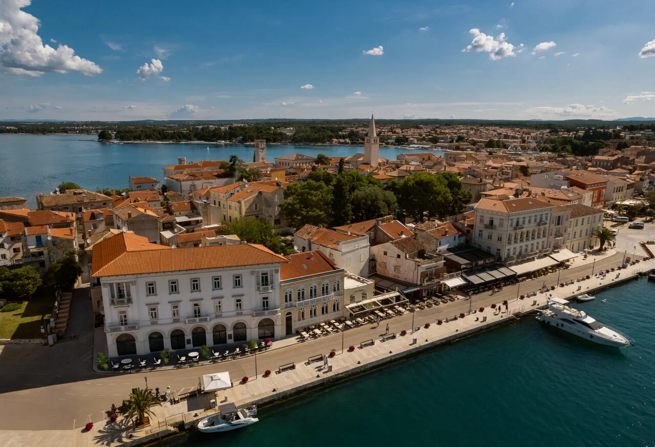 Luftansicht des Hafengebiets in der Altstadt von Poreč, mit dem Jadran Heritage Hotel an der Promenade, Terracotta-D&auml;chern, Kircht&uuml;rmen und Booten in der Adria. 