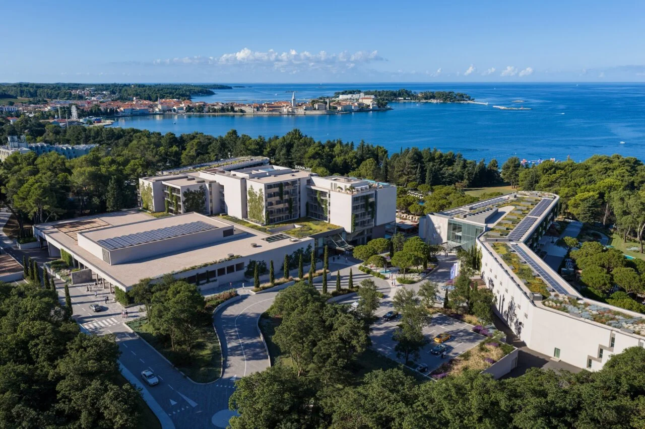 Luftaufnahme des Pical Resorts, Valamar Collection, eingef&uuml;gt in einen Kiefernwald, mit Blick auf die Bucht und die Altstadt von Poreč. 