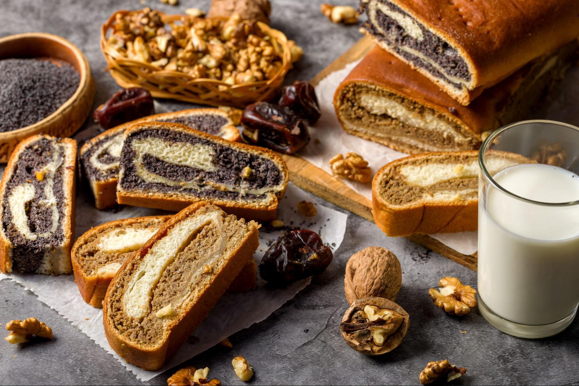 Slices of traditional Croatian Christmas rolls with poppy seed and walnut filling, served with nuts, dates and a glass of milk.