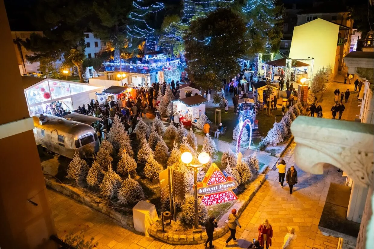 Pogled na Advent u Poreču s lampicama i posjetiteljima.