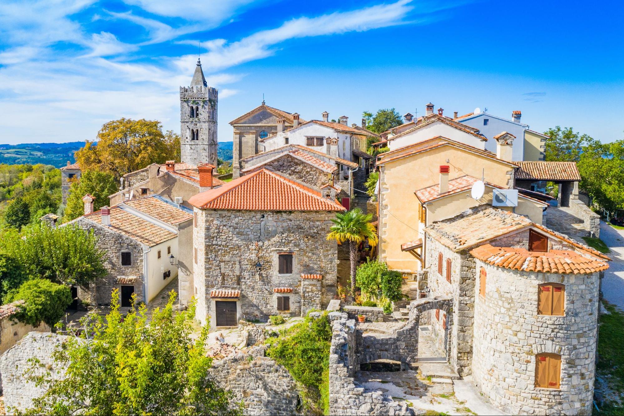 Panorama of Hum, the world’s smallest town, with stone houses and a church tower surrounded by greenery