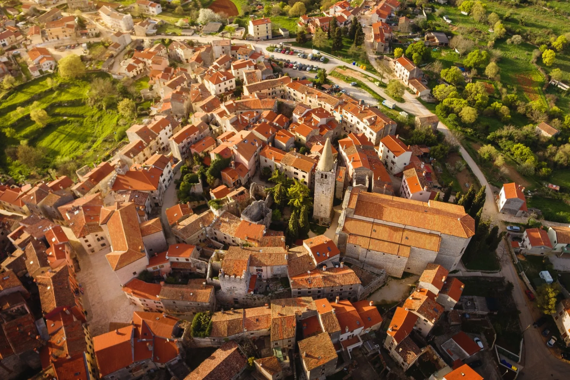 Old town of Bale with stone houses and a bell tower surrounded by greenery