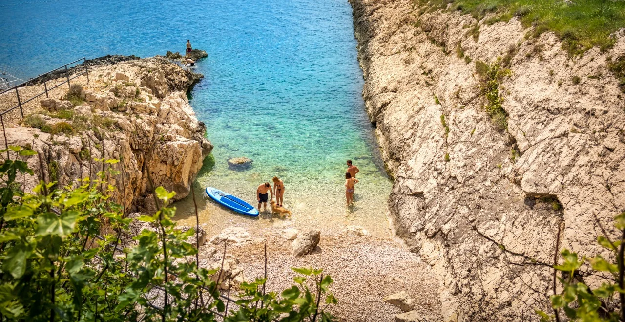 Natürlicher Strand zwischen Felsen im Camping Marina mit Blick auf die Kvarner-Bucht von Istrien aus