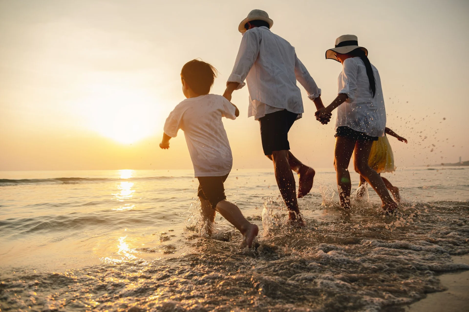 Family walking along the Adriatic shoreline at sunset during a summer holiday in Croatia