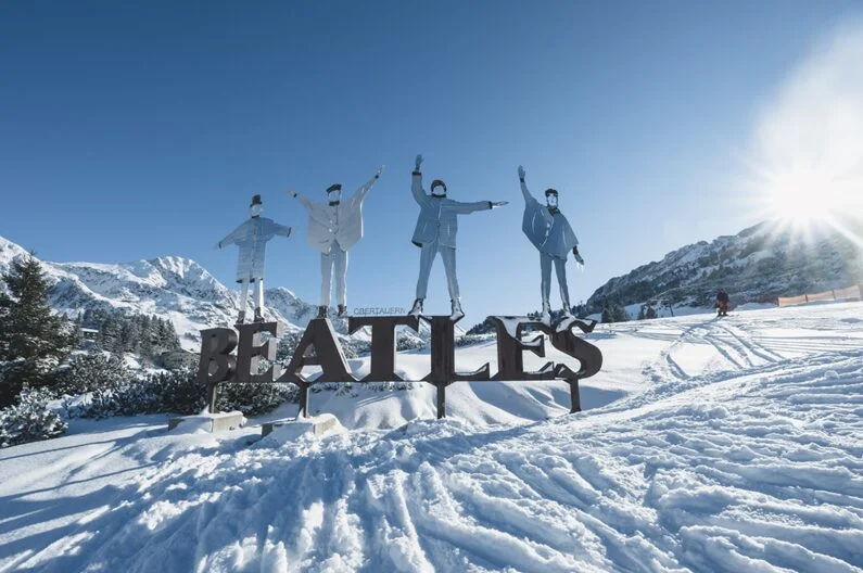 The Beatles monument near the Kirchb&uuml;hel lift, set in a snowy alpine landscape.