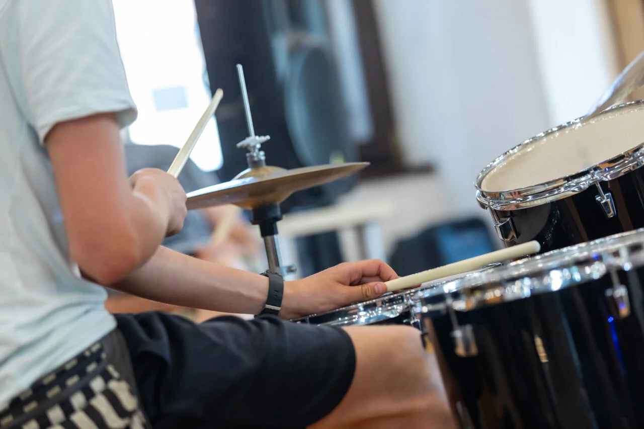 Ein Kind spielt Schlagzeug in einem Musik-Workshop im Kunstprogramm des Croatia Summer