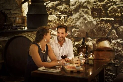 Couple enjoying wine in a rustic cellar on the island of Krk