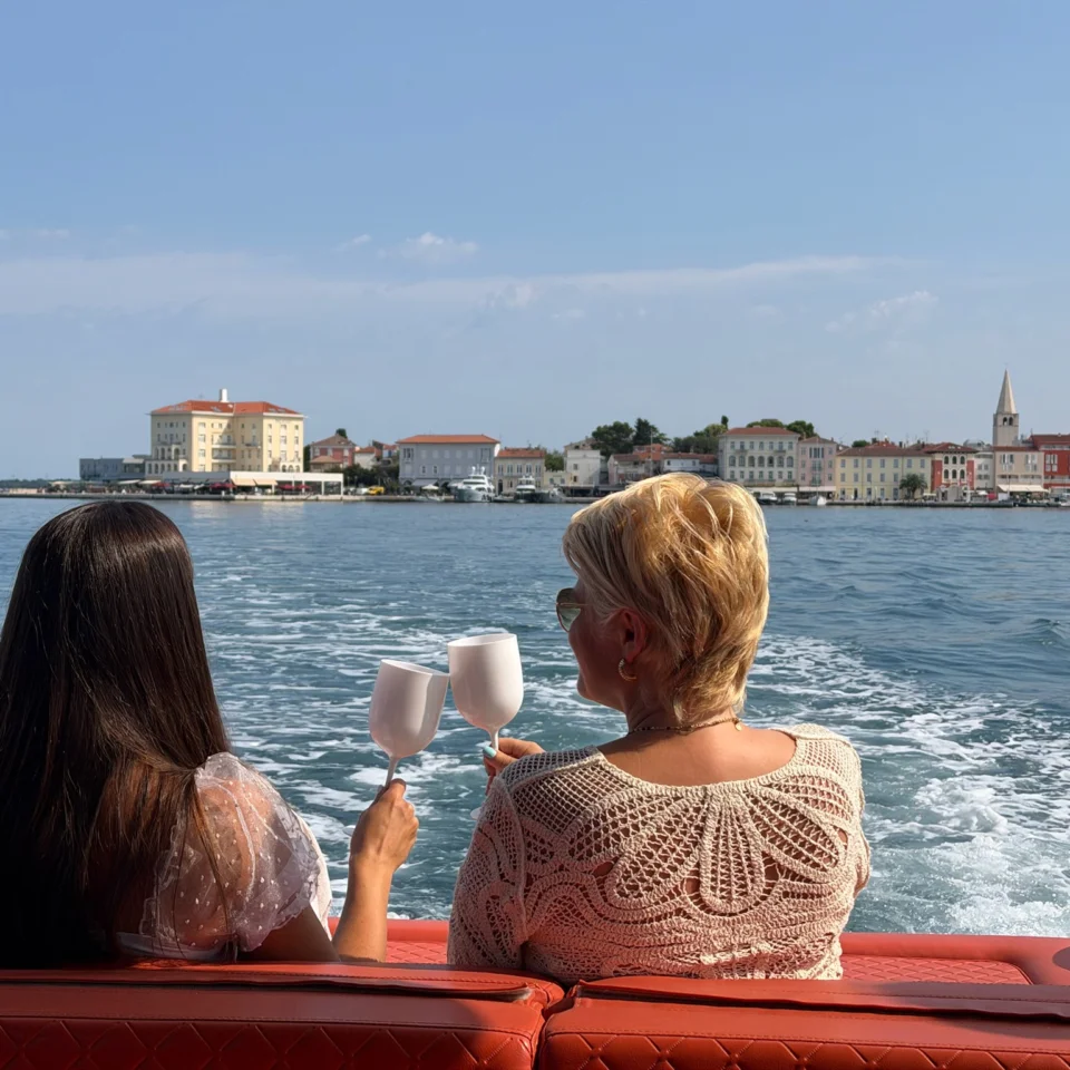 Dvije gošće nazdravljaju na gliseru uz pogled na Poreč s mora.