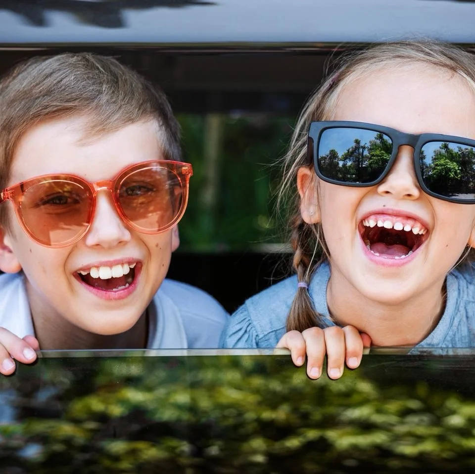 Children in a car seat looking out of the window during the journey to a holiday destination.