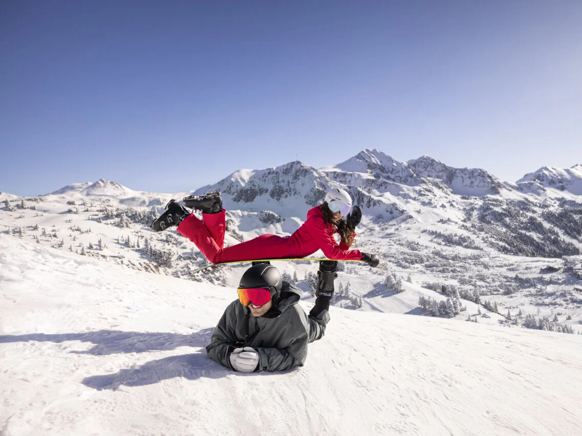 Skiers enjoying the snow on the slopes with panoramic views of the Alpine peaks.