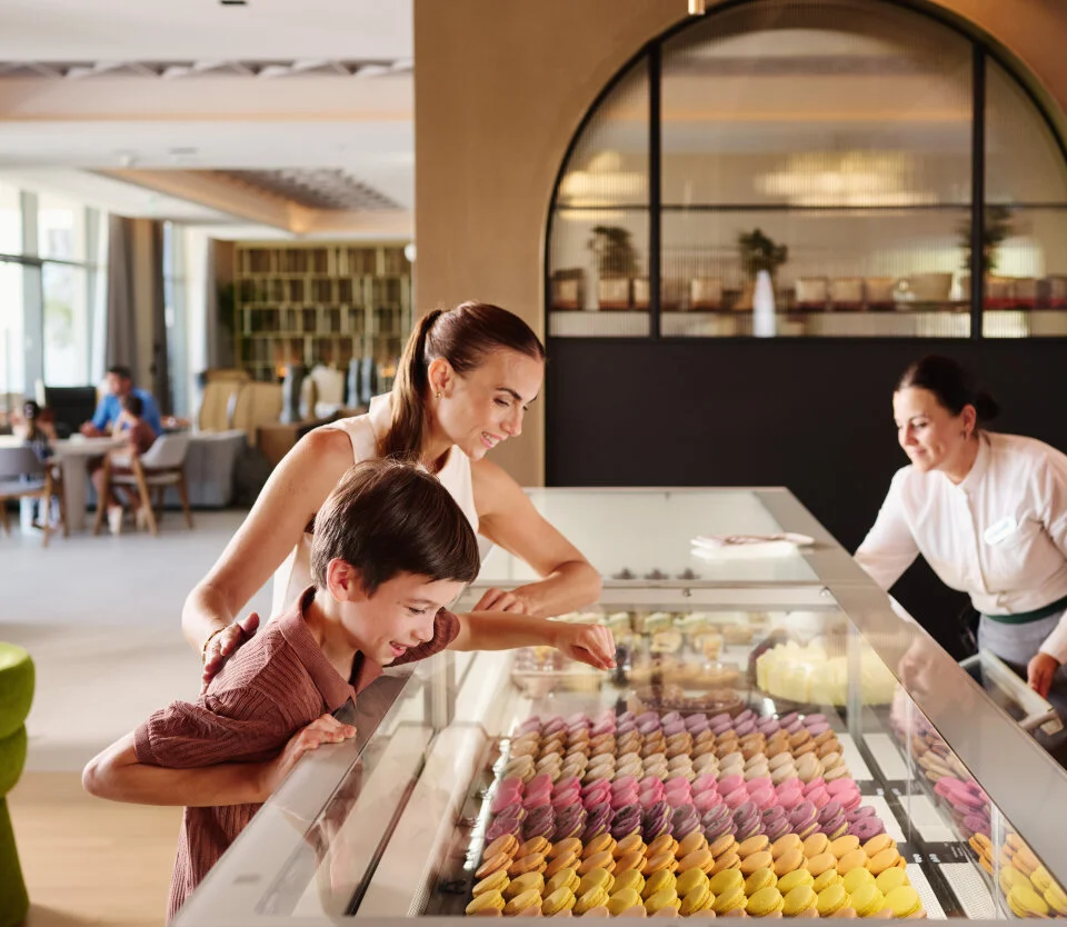 Mother and child choosing colourful macarons at Atelier 33 patisserie in Pical Resort 5*.

