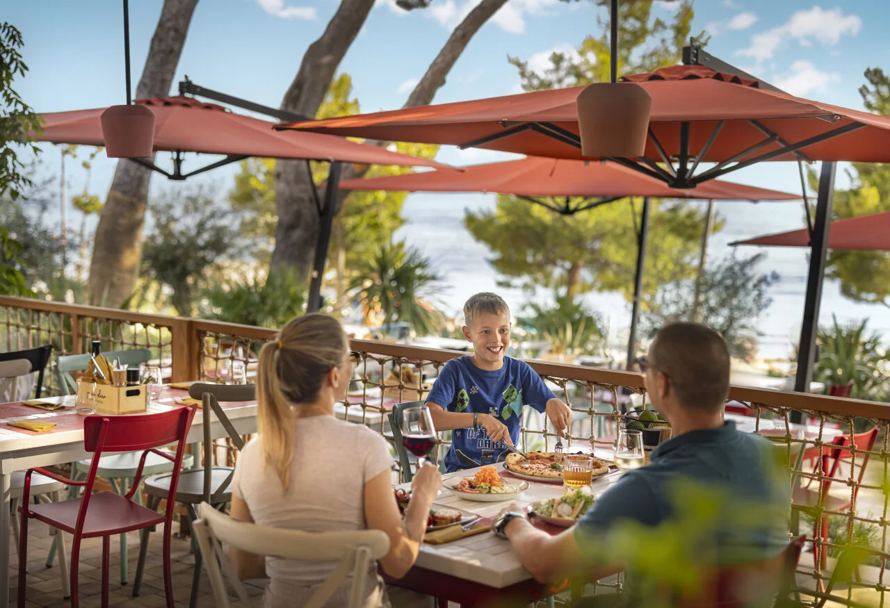 Family enjoying a meal outdoors at a family-friendly restaurant at Sunny Makarska by Valamar.