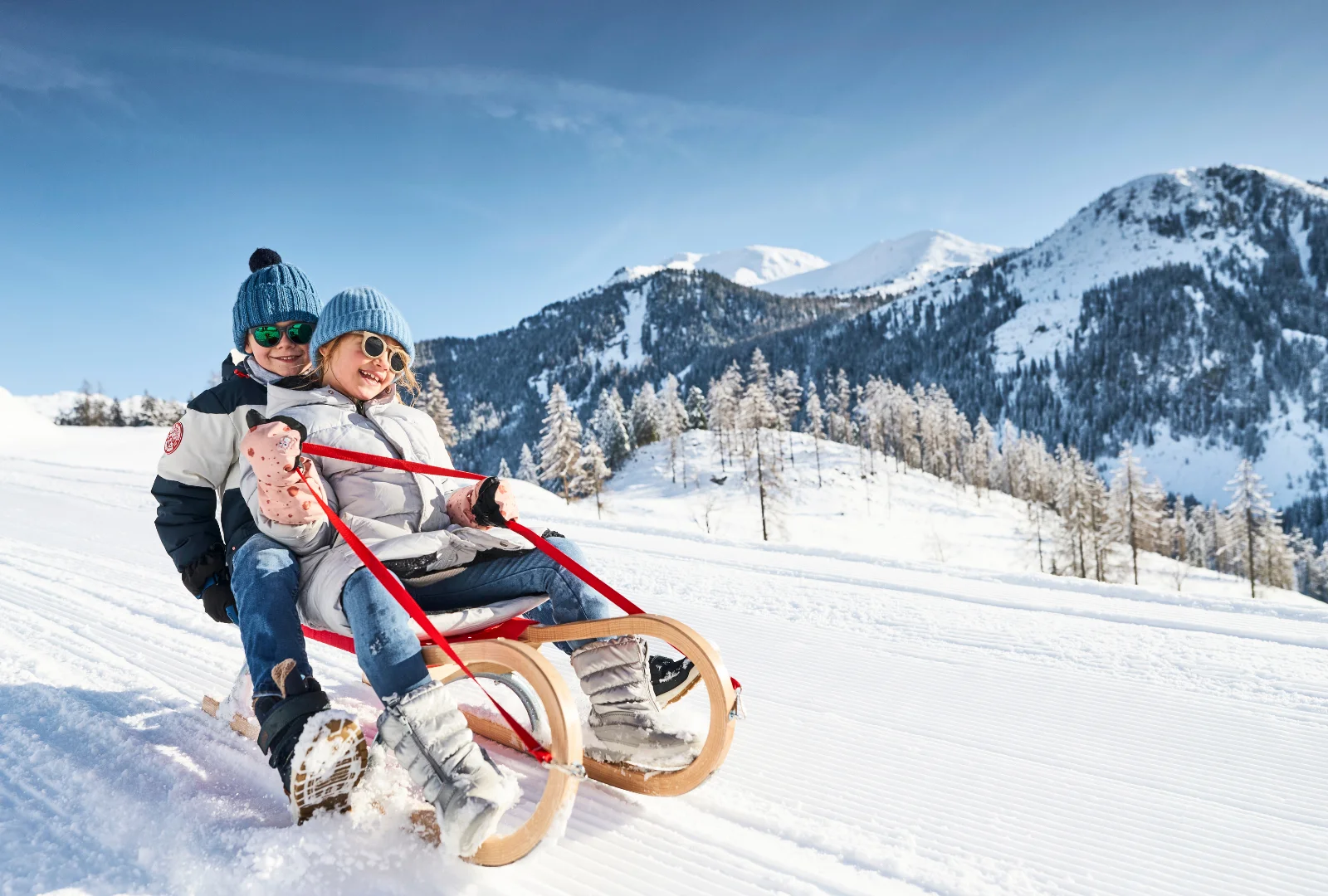 Children sledding in the snow during a winter holiday in Obertauern