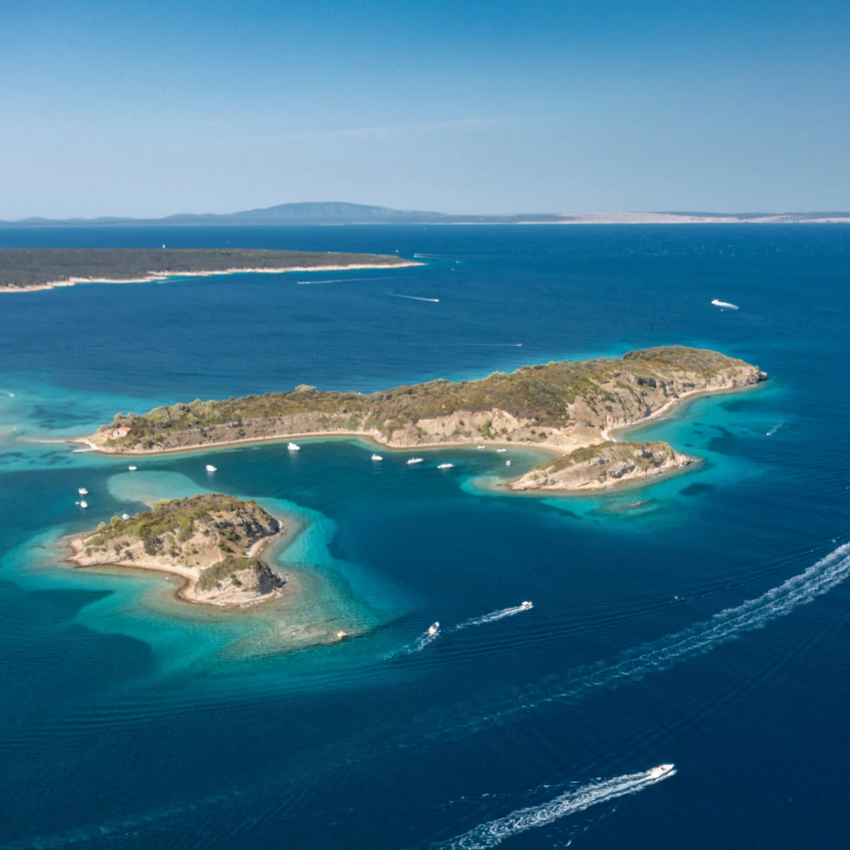 Pogled iz zraka na zelene otočiće i tirkizno more uz obalu otoka Raba