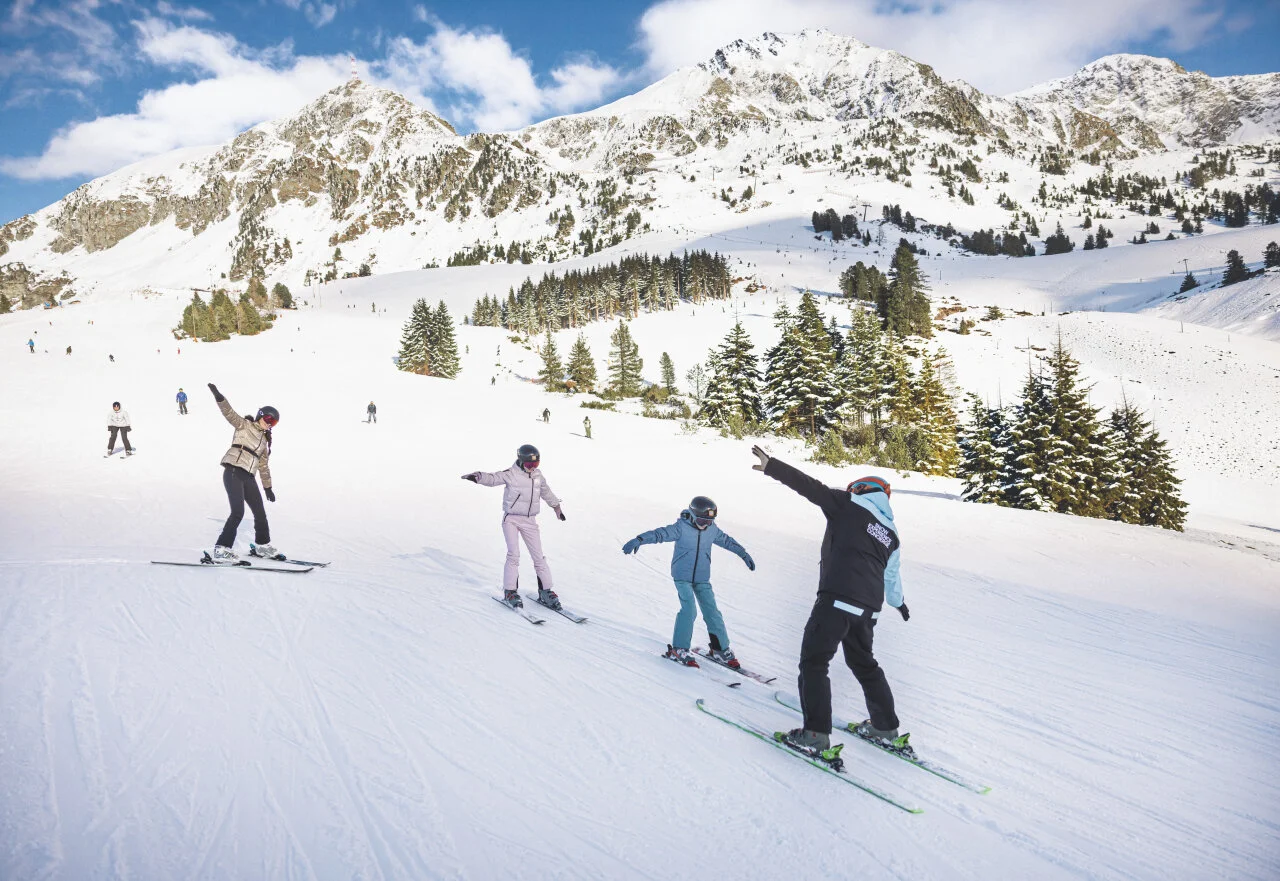 Obitelj uči skijati sa svojim Snow Experience vodičem tijekom zabavnog skijaškog odmora za djecu.