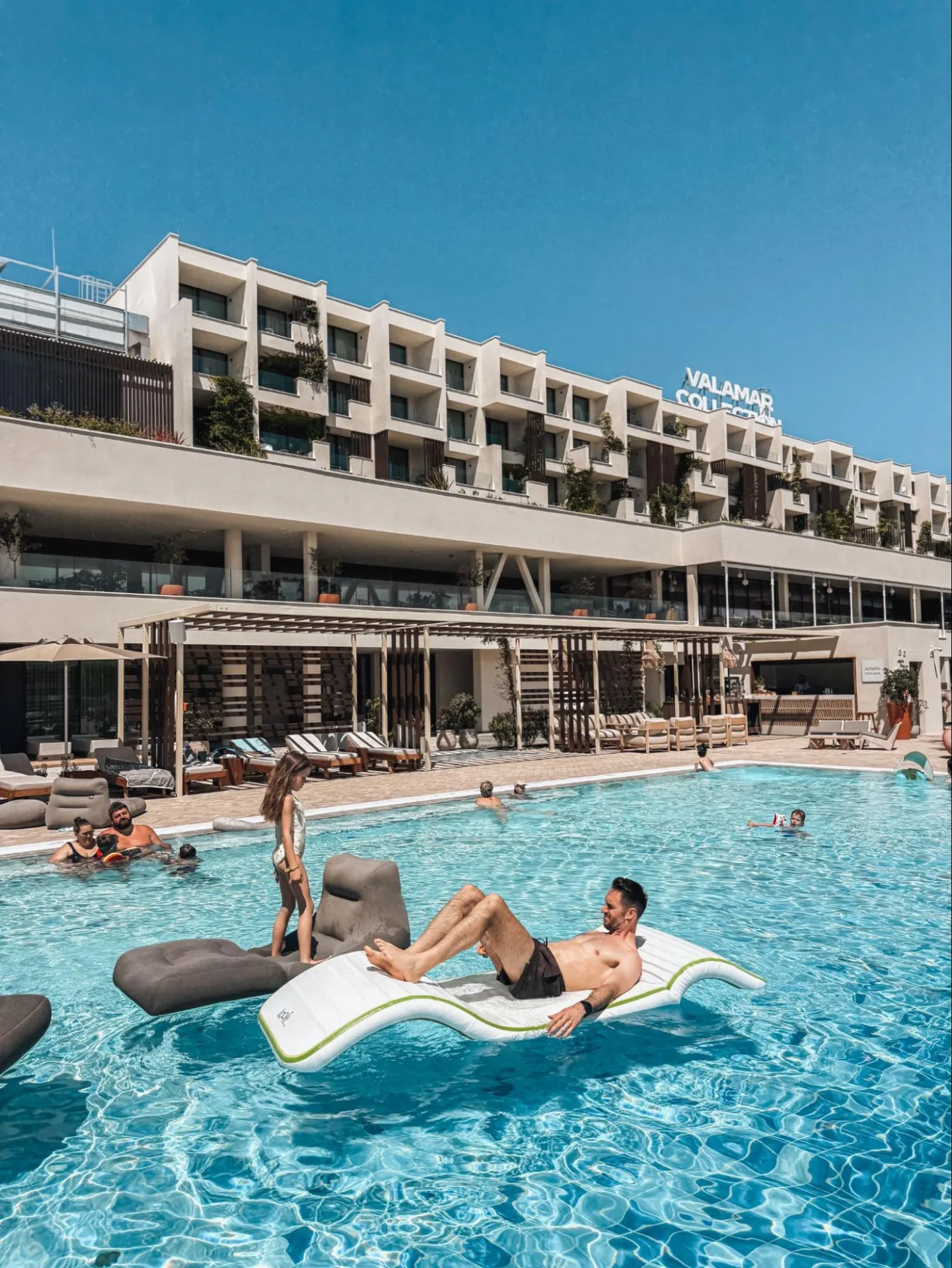 Guest relaxing on an inflatable float in the pool in front of Arba Resort.