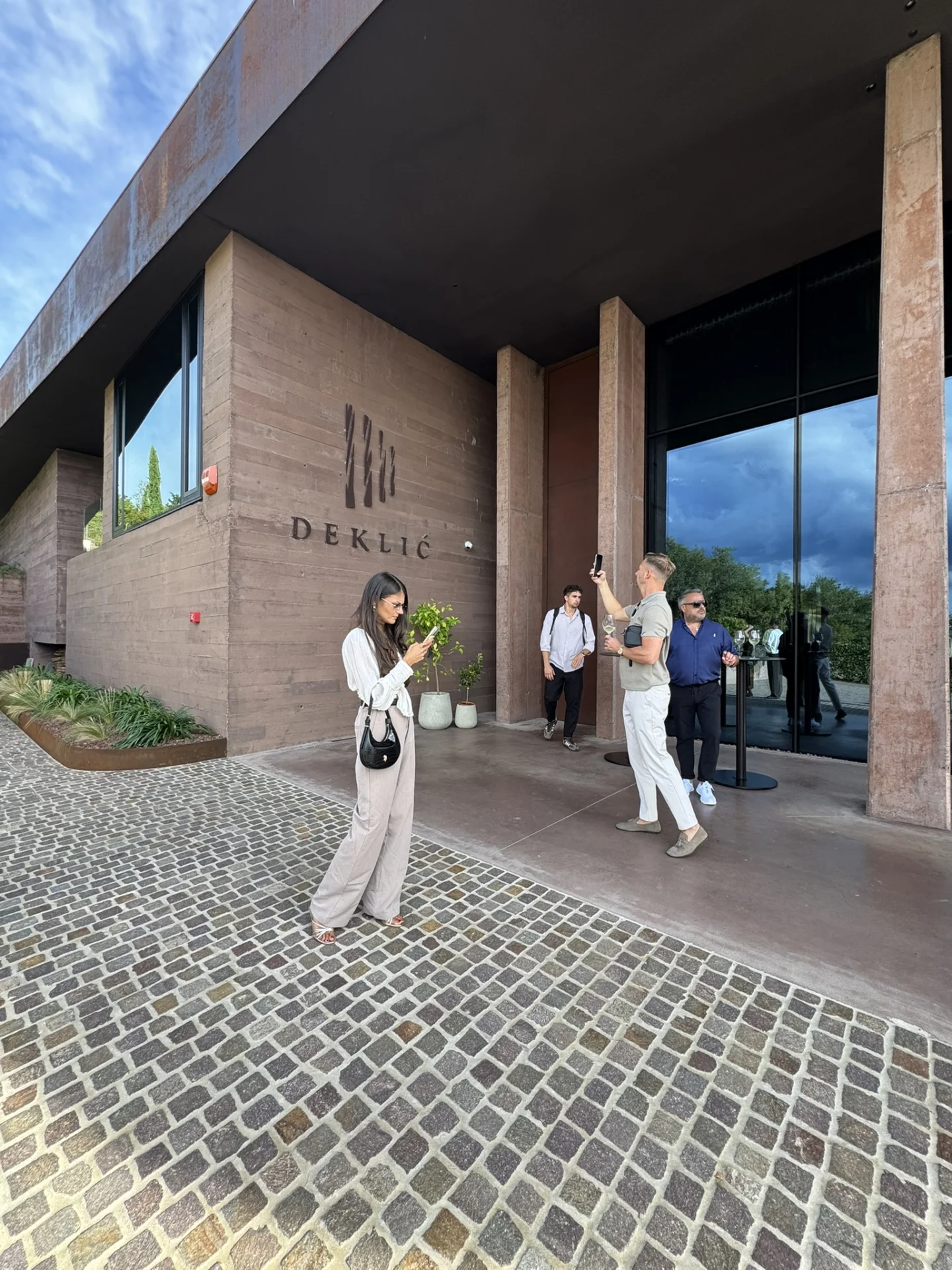 Visitors arriving at Deklić Winery near Vižinada, featuring its contemporary architecture and striking entrance.
