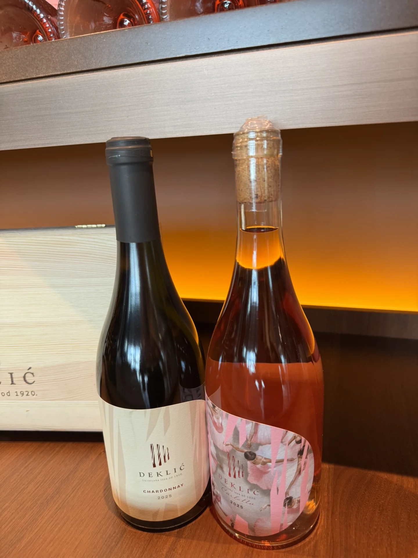 Two bottles of Deklić wine displayed during a winery tasting.
