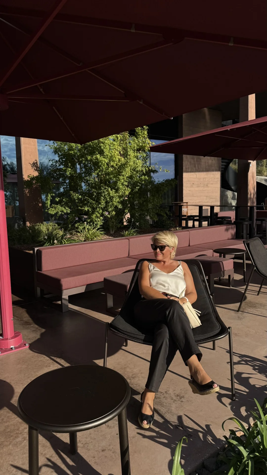 Woman relaxing on the sunny terrace of Deklić Winery in Istria, surrounded by modern outdoor furniture and greenery.