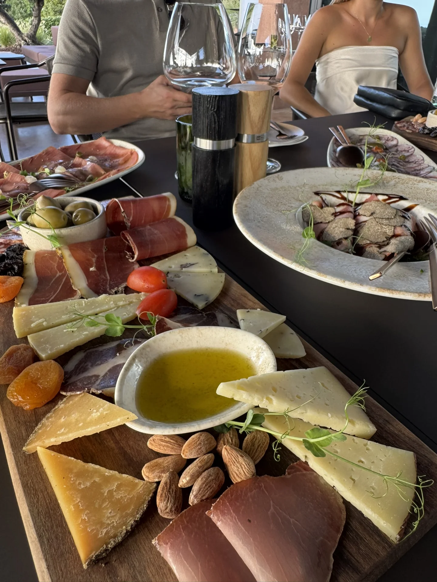 Selection of Istrian delicacies at Deklić Winery, featuring local cheeses, prosciutto, olives, almonds and olive oil served during a wine tasting.