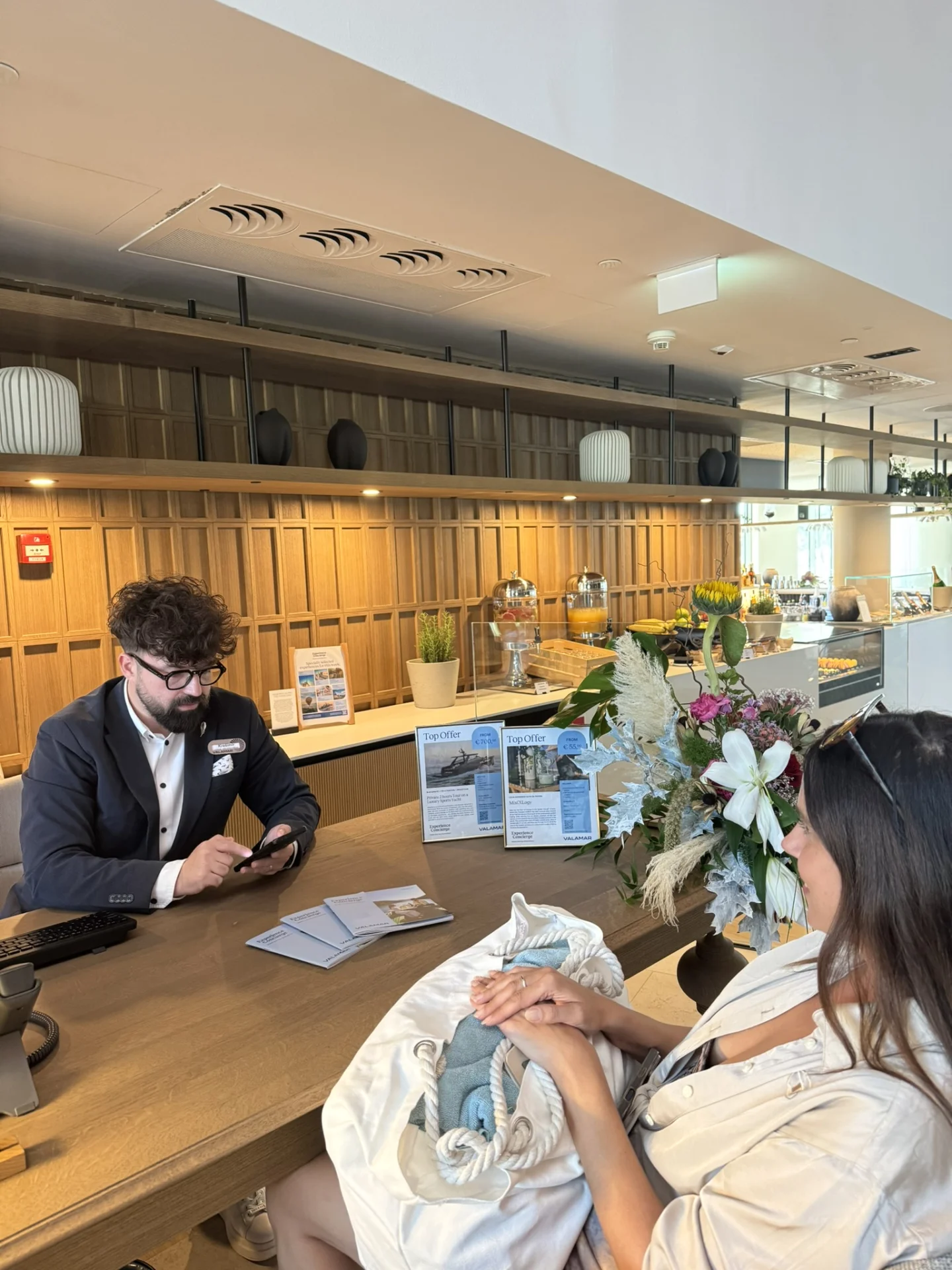 Guest speaking with the Experience Concierge at Pical Resort 5* while arranging restaurant reservations and local experiences. 
