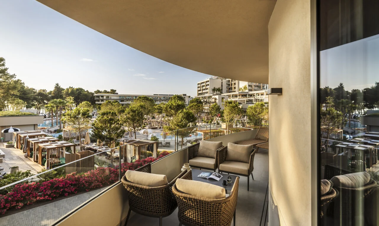 View from a restaurant terrace at Pical Resort 5*, overlooking the swimming pools, Mediterranean greenery and the sea in Poreč.