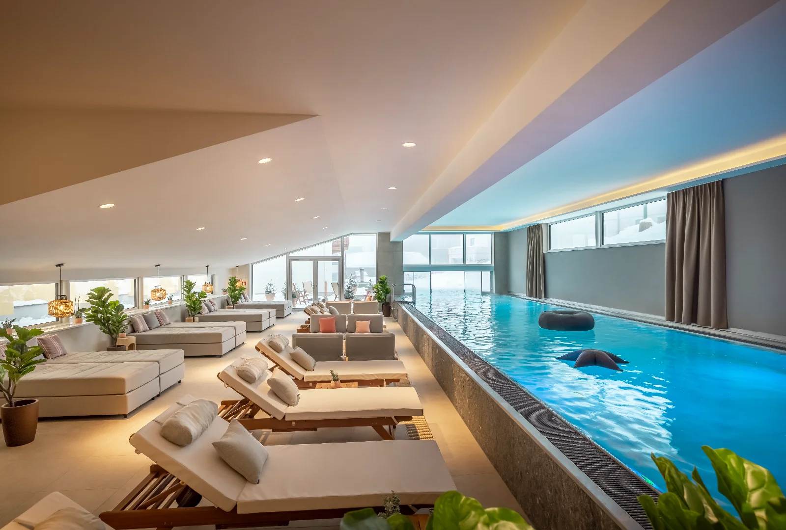 Heated indoor-outdoor pool at Valamar Obertauern Hotel surrounded by snowy Alpine scenery.