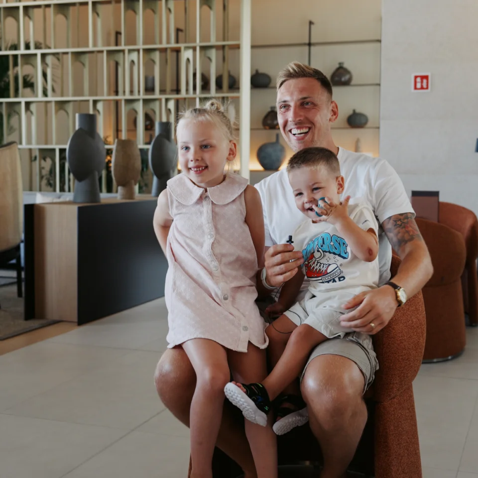 Alt: Smiling father with his two young children enjoying quality time together in the welcoming surroundings of Pical Resort 5* in Poreč.