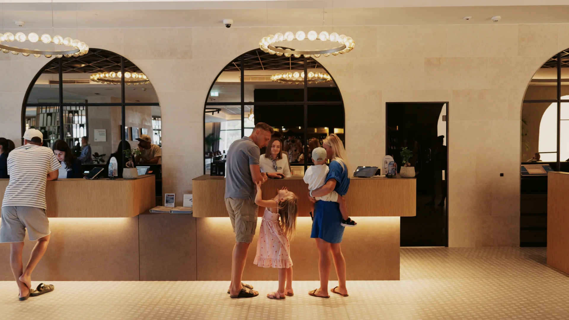 Family with children checking in at the reception of Pical Resort 5* in Poreč, in the elegantly designed hotel lobby.